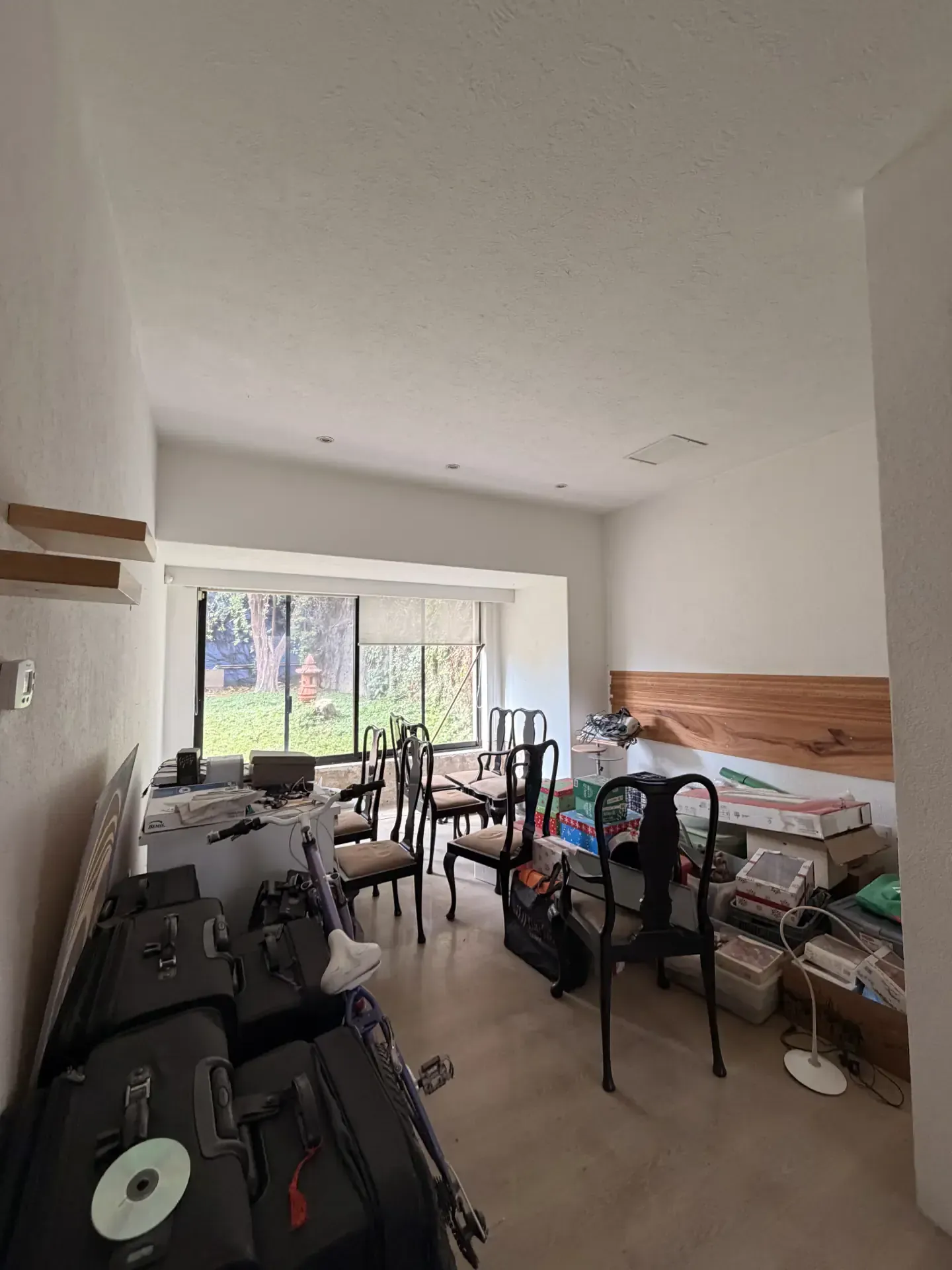 Habitación desordenada con sillas, cajas, maletas y objetos varios, lista para vaciado y demolición en Guadalajara.