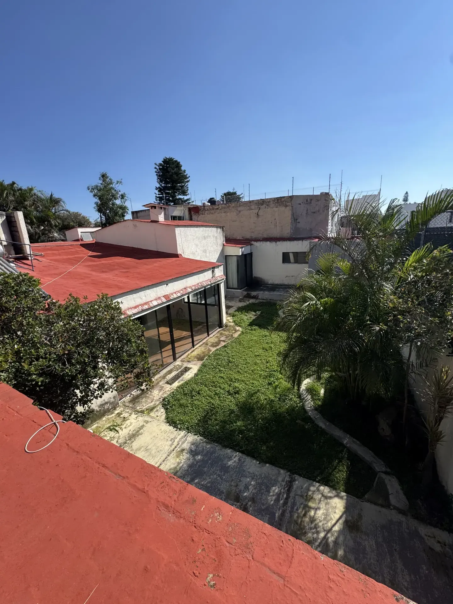 Vista aérea de una propiedad con techos rojos, jardín y edificios, ideal para demoliciones y excavaciones en Guadalajara.
